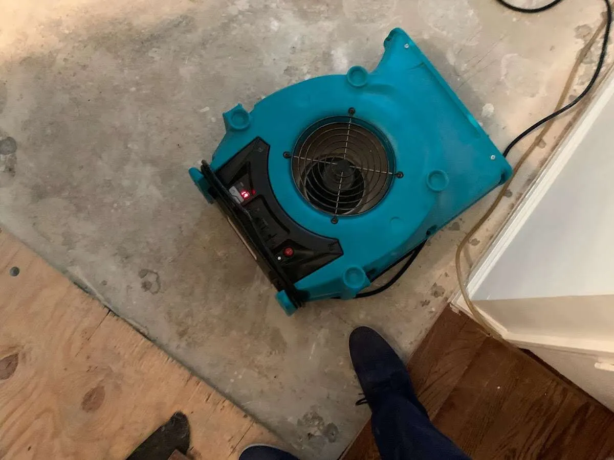 Air mover drying subfloor during Leak Detection & Repair in Reminderville